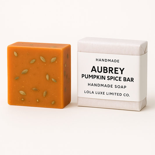 Orange handmade soap bar with pumpkin spice scent next to its packaging on a white background
