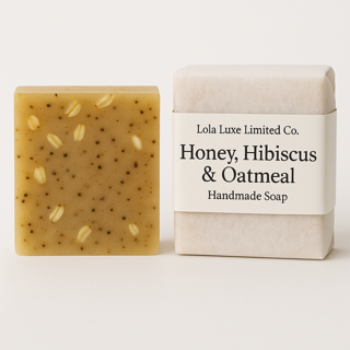 Handmade soap bar with visible seeds next to its packaging on a white background